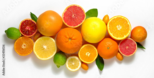 Close up image of juicy organic whole and halved assorted citrus fruits  green leaves   visible core texture  isolated white background  copy space. Vitamin C loaded food concept. Top view  flat lay.