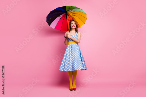 Full length photo of cheerful fancy lady hold bright umbrella look copyspace enjoy rainy day weekend wear yellow blue headband red shoes tights isolated over pink color background