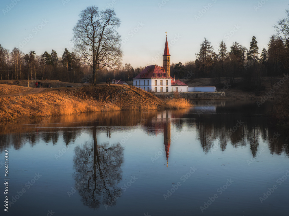 Beautiful color landscape with a blue lake an old castle and reflections in the water in early spring Beautiful color landscape with a blue lake an old castle and reflections in the water in early spring