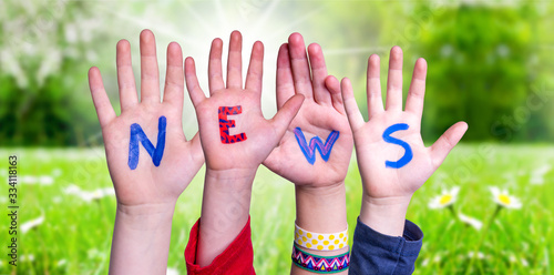 Children Hands Building Colorful English Word News. Sunny Green Grass Meadow As Background