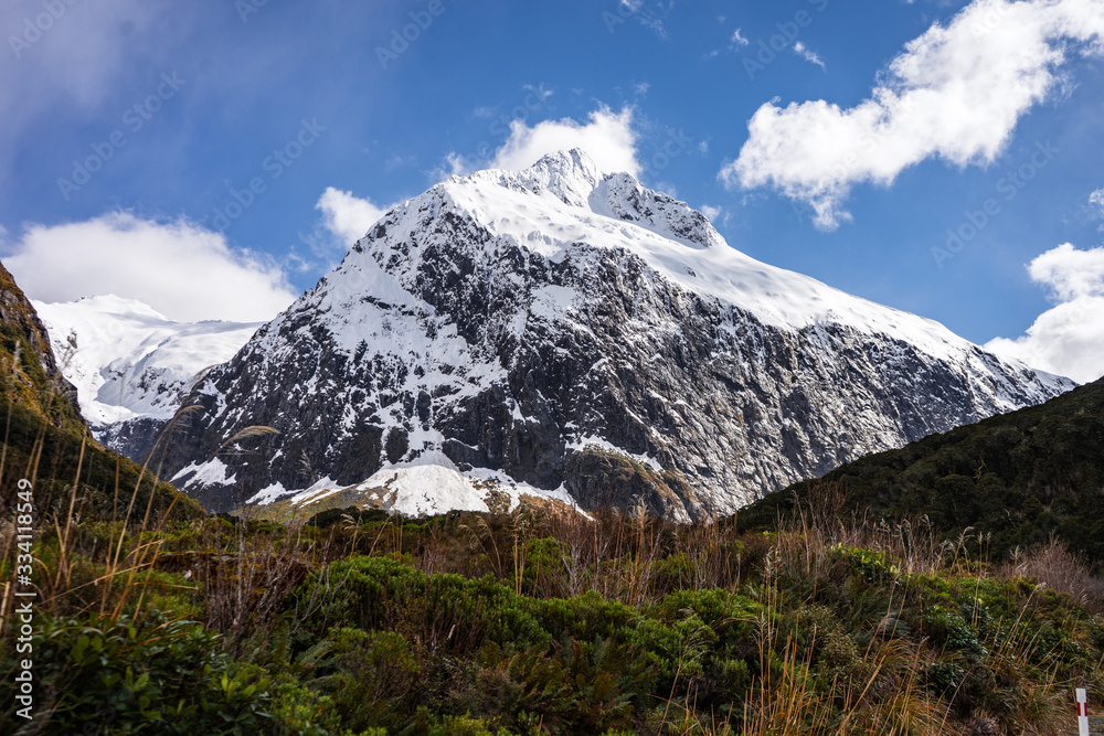 Stunning image of a snowy mountain on the SH94 road to Milford Sound taken on a sunny winter day, New Zealand