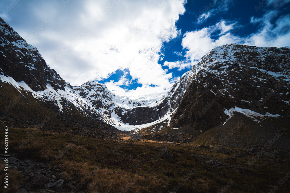 Stunning image of a snowy mountain on the SH94 road to Milford Sound taken on a sunny winter day, New Zealand