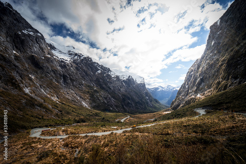 Stunning panorama of the SH94 road to Milford Sound from Hommer Tunnel with the snow capped mountains in the background taken in spring, New Zealand