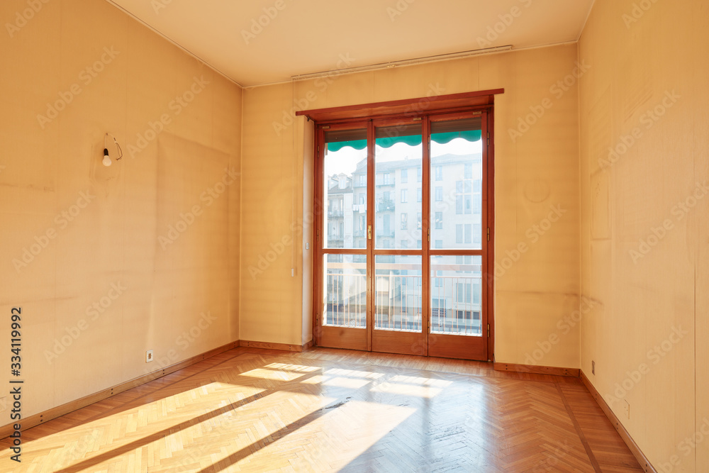 Sunny room with wooden floor in old apartment interior