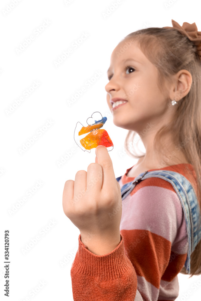 Little girl with orthodontics appliance isolated on white background. Little girl with orthodontics appliance isolated on white background.