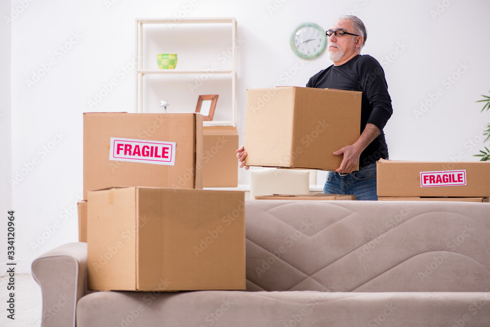 Old male professional mover doing home relocation