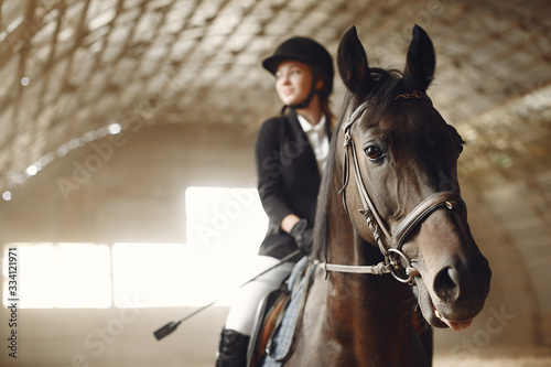 Woman on a horseback. Rider in a black uniform