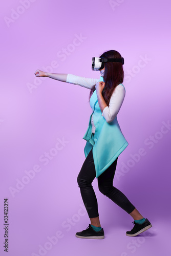 Woman is using virtual reality headset, playing game and fighting.