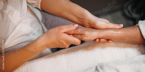 Hand massage session with special cream done at the spa salon to a young woman