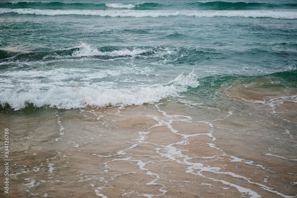 The coast of the Indian Ocean at dawn in Sri Lanka in March 2020. Calm beautiful water and azure blue waves