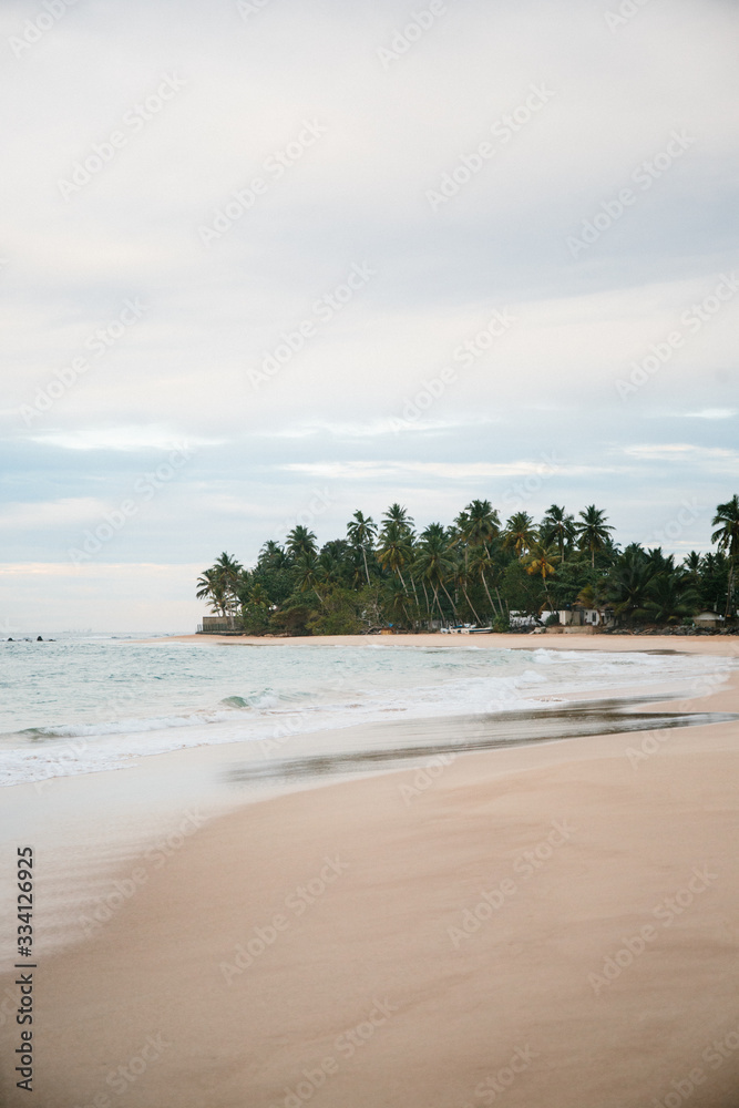 The coast of the Indian Ocean at dawn in Sri Lanka in March 2020. Calm beautiful water and azure blue waves