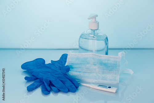 Coronavirus prevention set, hand sanitizer gel, protective mask, gloves and thermometer. COVID-19 concept. Health protection. Copy space.