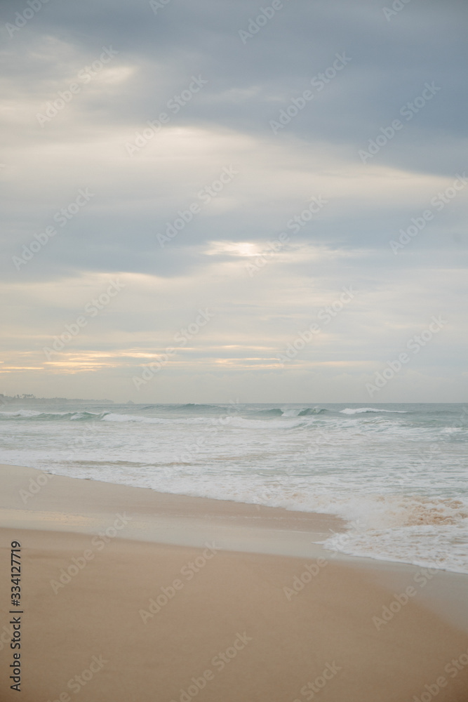 The coast of the Indian Ocean at dawn in Sri Lanka in March 2020. Calm beautiful water and azure blue waves