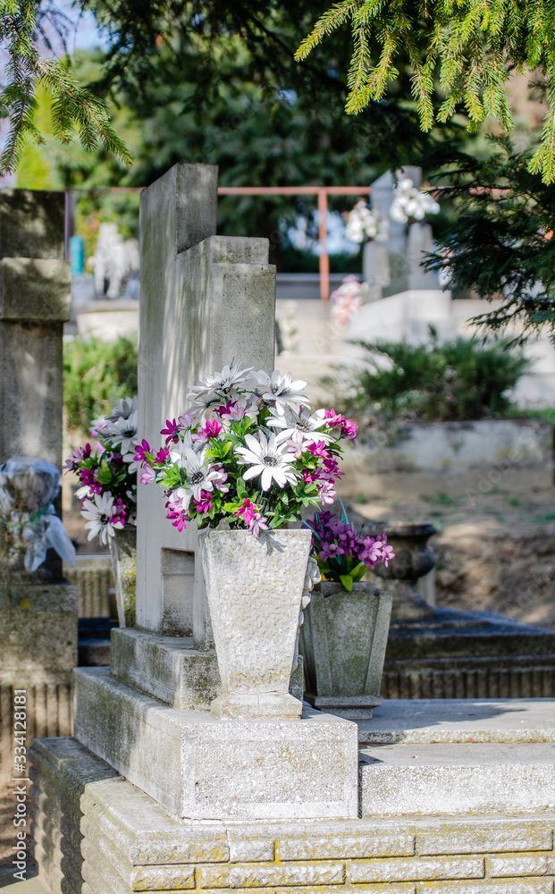EUropean cemetery - plastic flowers bouquet on a tombstone - springtime scene