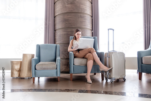 Young handsome blogger influencer writes review on hotel website. Young marketing specialist writes a report on a working trip. Female freelancer works remotely communicates in messenger with employer