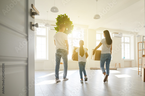Foto Happy family with children moving with boxes in a new apartment house
