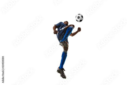 Football or soccer player on white background with grass. Young male sportive model training  practicing. Attacking  catching. Concept of sport  competition  winning  motion  overcoming. Wide angle.