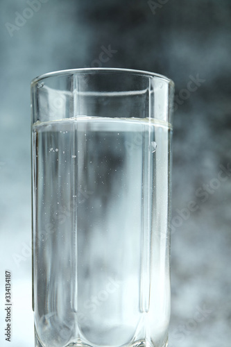 Glass of pure water on the grey background photo