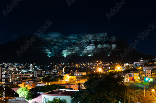 Gorgeous night long exposure from Bo-Kaap or Malay Quarter with illumination lights at edge of Table Mountain. The city of Cape Town is a famous travel destination in Africa. February 2020