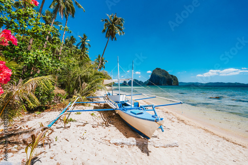 Fototapeta Naklejka Na Ścianę i Meble -  The Philippines's Banca boat. Traditional fishing boat on beach in noon bright sun. El Nido,Palawan