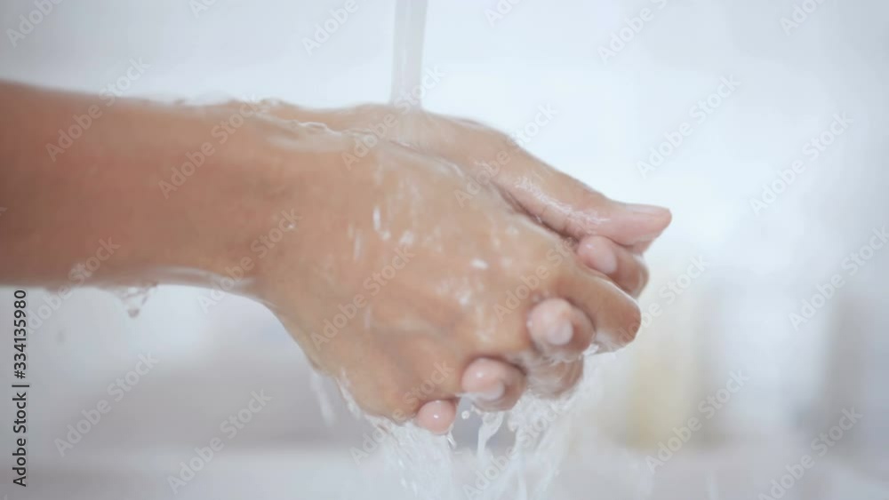 Close up lathering hands with soap hand sanitizer gel then water washing in toilet to prevent Coronavirus pandemic Close up lathering hands with soap hand sanitizer gel then water washing in toilet to prevent Coronavirus pandemic