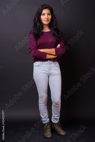 Full body shot of young beautiful Indian woman with arms crossed