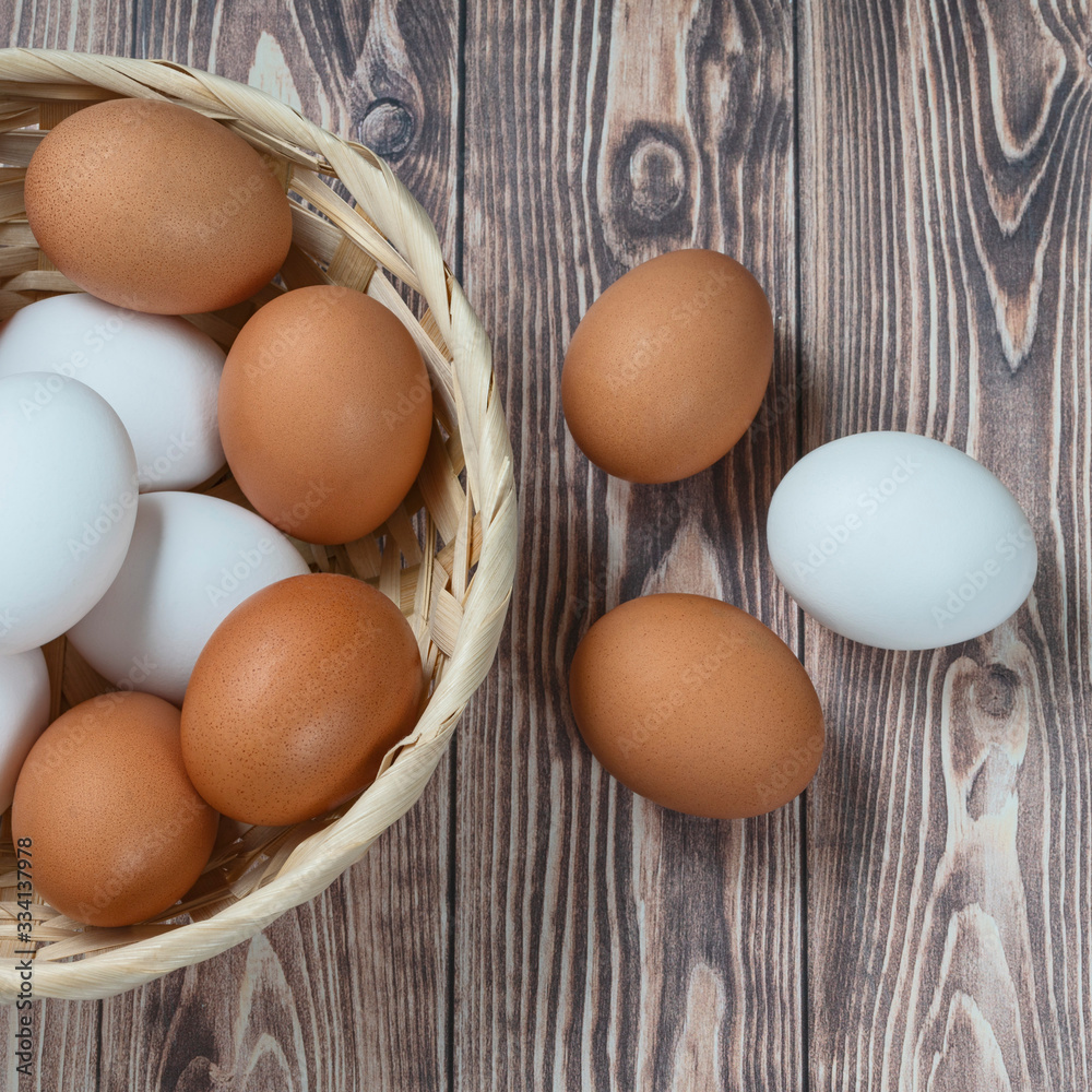 several fresh chicken eggs in a straw basket on a wooden background. Healthy eating concept several fresh chicken eggs in a straw basket on a wooden background. Healthy eating concept