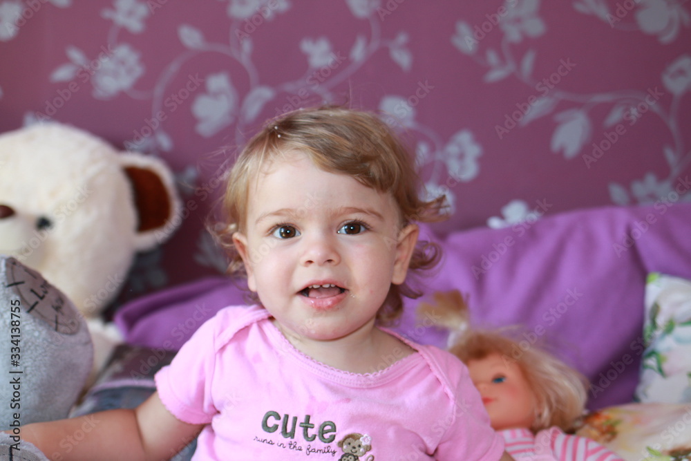 Cute little Caucasian girl one year old plays in her room with soap bubbles, laughs merrily, close-up. Childhood, leisure, games. Cute little Caucasian girl one year old plays in her room with soap bubbles, laughs merrily, close-up. Childhood, leisure, games.