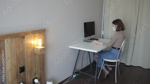 A young girl is working on a computer in her room during quarantine and then does a shoulder massage.Coronavirus. COVID-19 photo