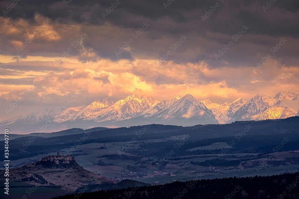 Mountain range landscape view with Spis castle at sunrise, High Tatras, Slovakia