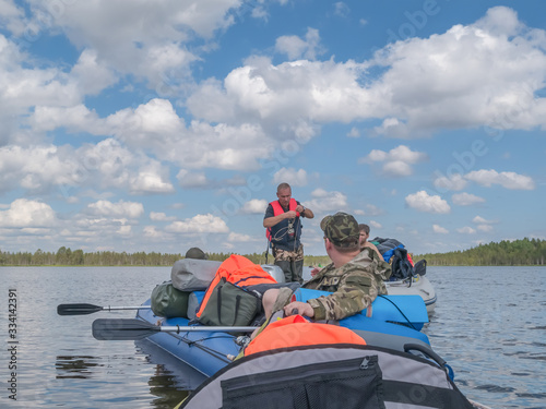 Landscape of harsh Karelian nature with boats in lake. Active extreme ecotourism in Karelia. Water rafting © Natalia