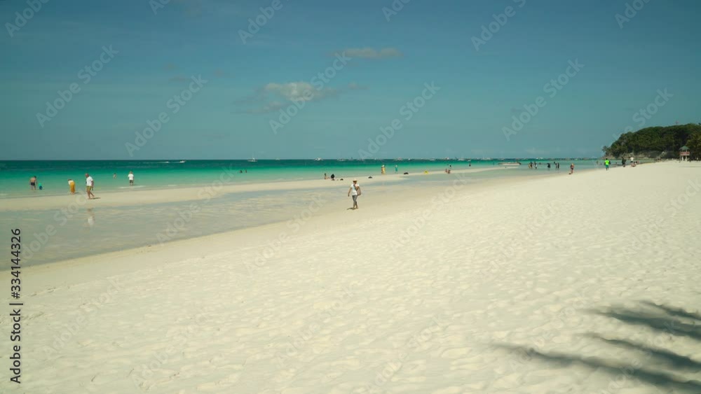 Sandy beach with tourists and turquoise water in the tropical resort of Boracay, Philippines. Sandy beach with tourists and turquoise water in the tropical resort of Boracay, Philippines.