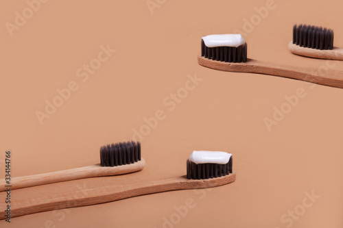A row of wooden toothbrushes on a brown background.