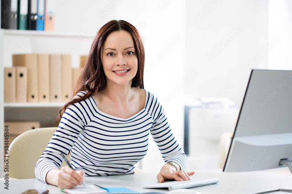 Portrait of a business woman at workplace in office Portrait of a business woman at workplace in office