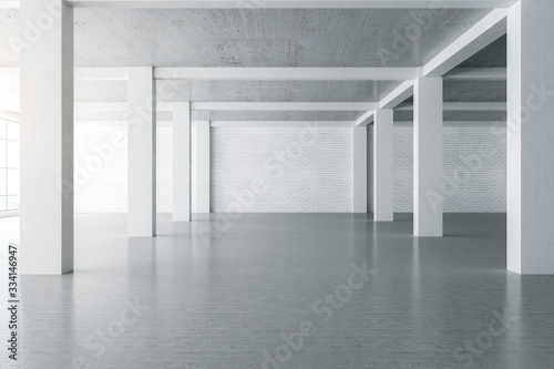 Contemporary concrete interior with blank brick wall.