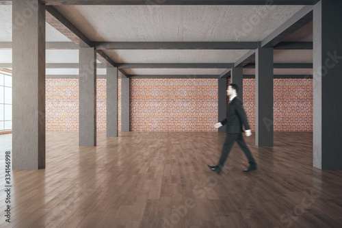 Businessman walking in modern gallery interior