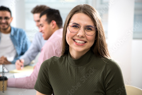 Portrait of a happy female student against the background of his friends
