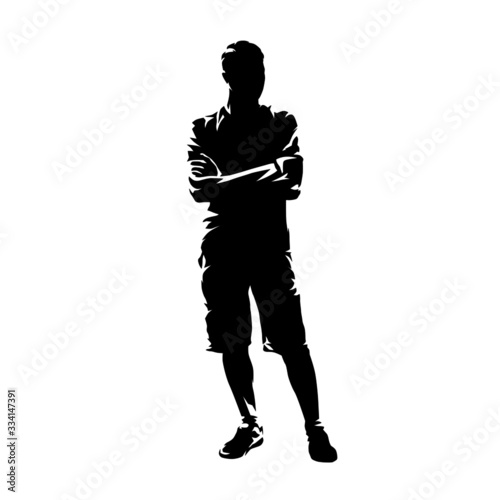 Young man standing with folded arms. Guy wearing shorts and shirt, summer clothing. Isolated vector silhouette, abstract ink drawing