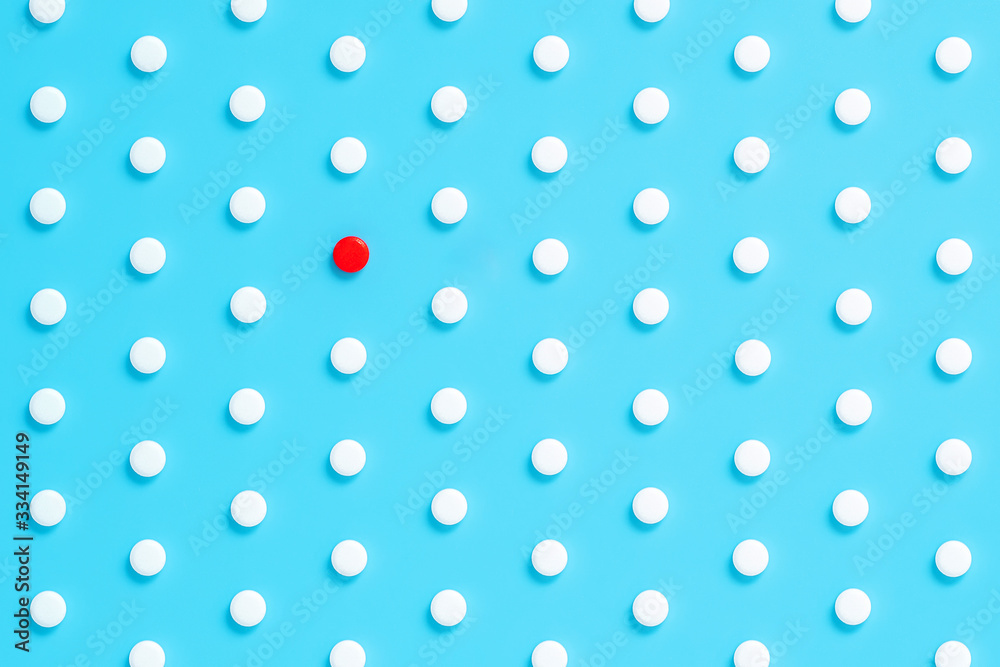 pattern of pills on a blue background. pill is different from others. pattern of pills on a blue background. pill is different from others.