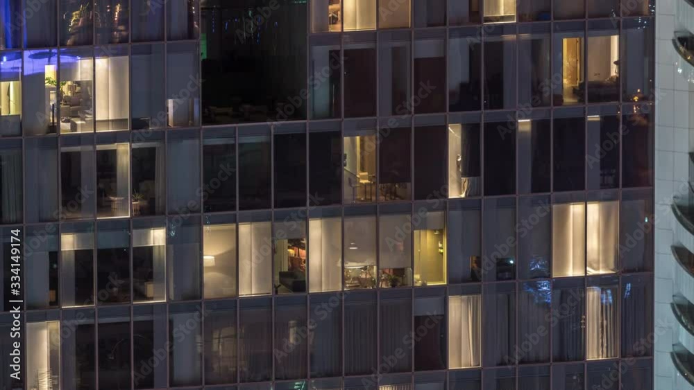 Night view of office and apartment building timelapse. High rise skyscraper with blinking windows with people moving inside. Aerial view from above Night view of office and apartment building timelapse. High rise skyscraper with blinking windows with people moving inside. Aerial view from above