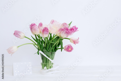 Wallpaper Mural Tulip flowers in glass vase with gift card over white background isolated Torontodigital.ca