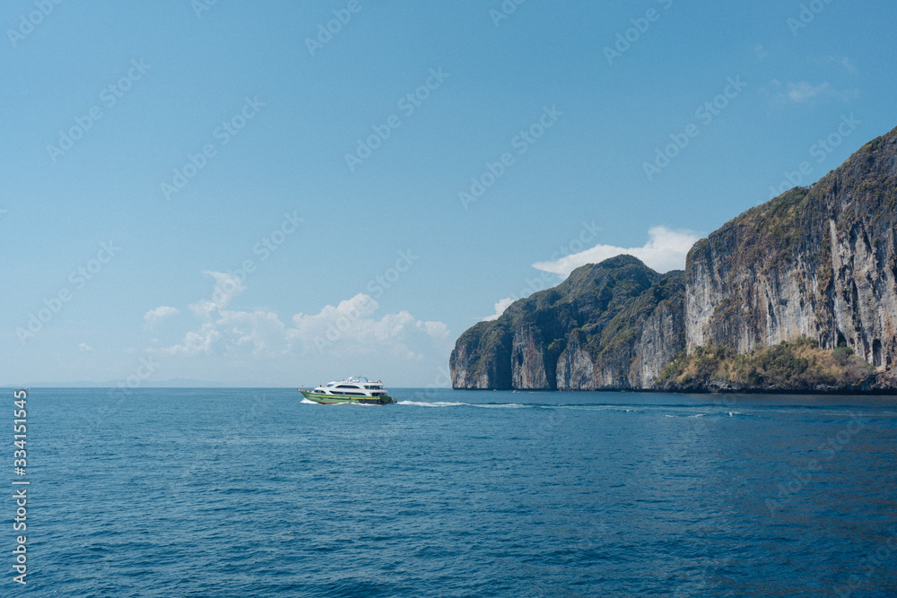 island in the sea with the boat and blue sky