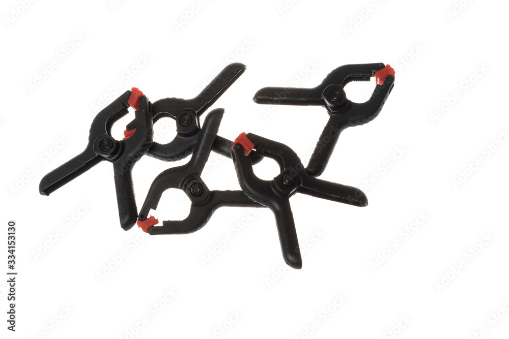 Pile of black plastic clamps with red tips, isolated on white background Pile of black plastic clamps with red tips, isolated on white background