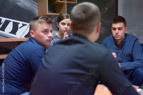 Fototapeta Naklejka Na Ścianę i Meble -  Group of a young business people brainstorming and discussing business plan on meeting at sunny bright office interior.