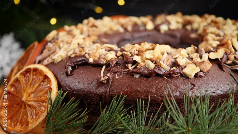 Festive Christmas cupcake with orange slices and nuts on the background of a New Year's garland. Circle motion Festive Christmas cupcake with orange slices and nuts on the background of a New Year's garland. Circle motion