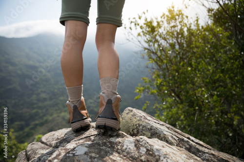 Successful hiker enjoy the view on mountain top cliff edge