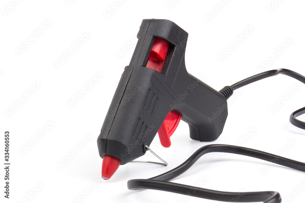 Electric hot glue gun on white background. Rods for glue gun Electric hot glue gun on white background. Rods for glue gun