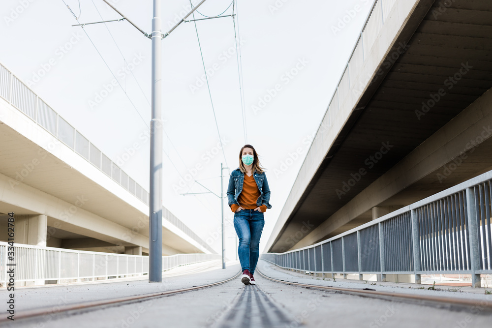 custom made wallpaper toronto digitalYoung woman with a surgical mask in an empty tram station