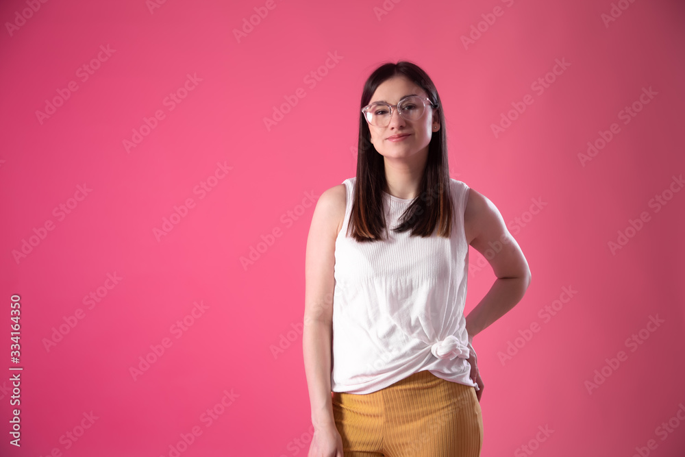 Portrait of a young woman with glasses on a pink background. Portrait of a young woman with glasses on a pink background.