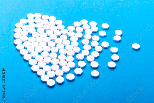 Heart of pills on a blue background.